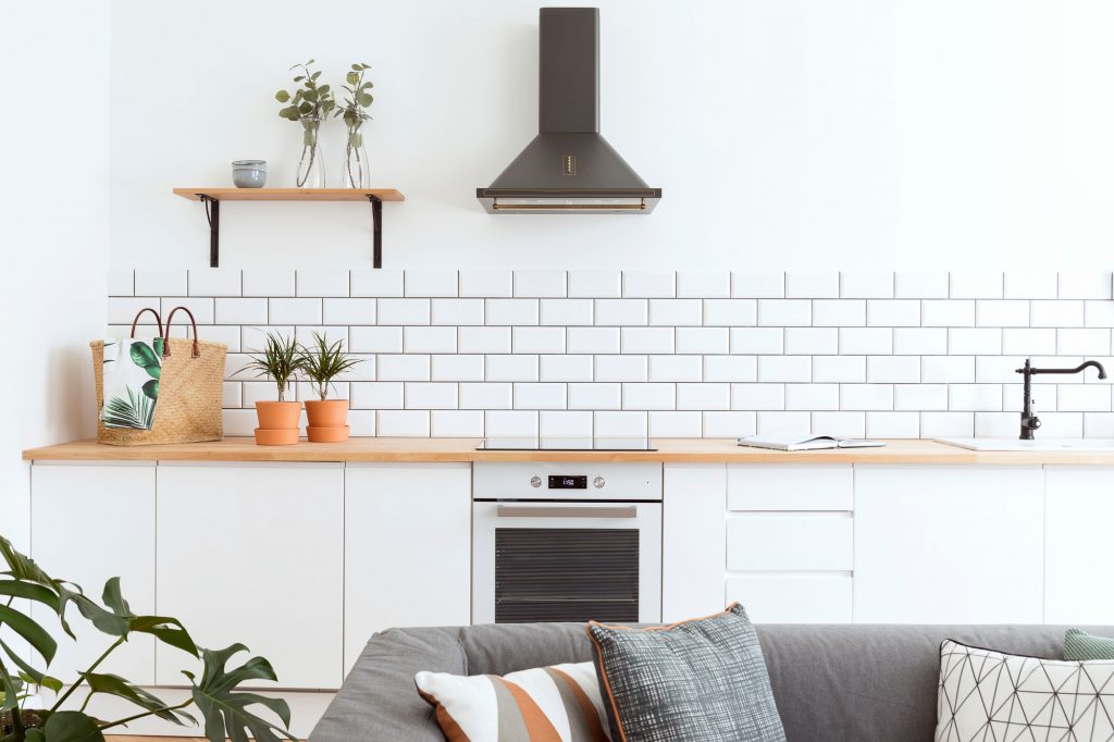 Home staging with white kitchen with subway tile backsplash and house plants